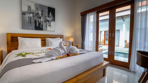 two swans sitting on a bed in a bedroom at Royal Crown Villas in Ungasan