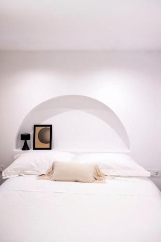 a bedroom with a white bed with a white headboard at Casa Amore in Ermoupoli