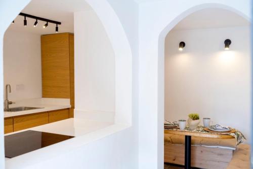 a kitchen with white walls and a table with dishes on it at Casa Amore in Ermoupoli