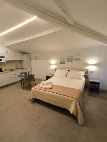 a bedroom with a large bed and a kitchen at Villa Ander in Colà di Lazise