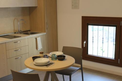 a small kitchen with a table and chairs and a window at Villa Ander in Colà di Lazise
