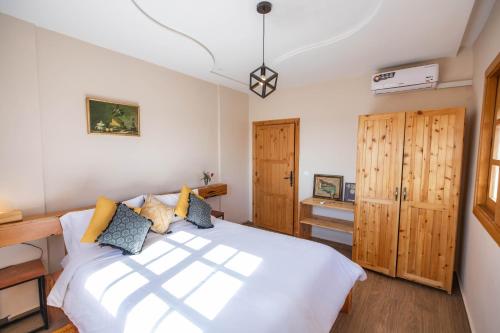 a bedroom with a white bed and wooden cabinets at Bio et Bois -Luxury Bio Farm- in Moulay Yacoub