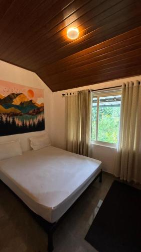 a bedroom with a large white bed with a window at Hang on in Anachal