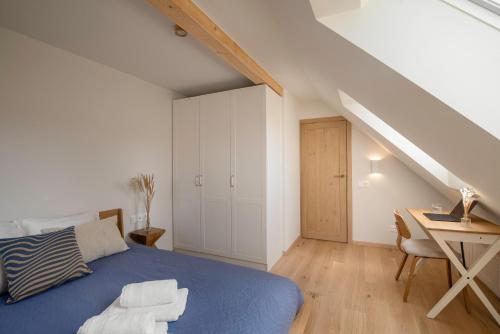 a bedroom with a blue bed and a desk at Sava Nida in Neringa