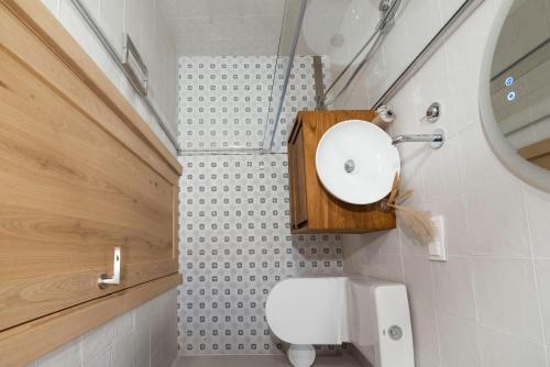 a bathroom with a white toilet and a mirror at Sava Nida in Neringa