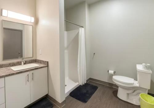 a white bathroom with a toilet and a sink at Evergreen Nook in Des Moines