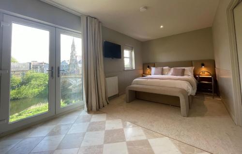a bedroom with a bed and a large window at Riverside Stay in Morpeth