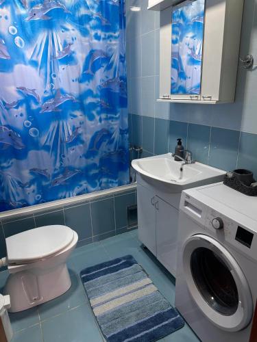 a bathroom with a toilet and a sink and a washing machine at Green Garden Apartments in Surčin