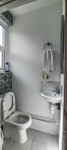 a white bathroom with a toilet and a sink at Maindee Guest House in Barrow in Furness