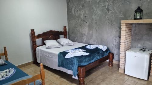 a bedroom with a bed and a fireplace at Pousada Cachoeira do Campo in Aquidauana