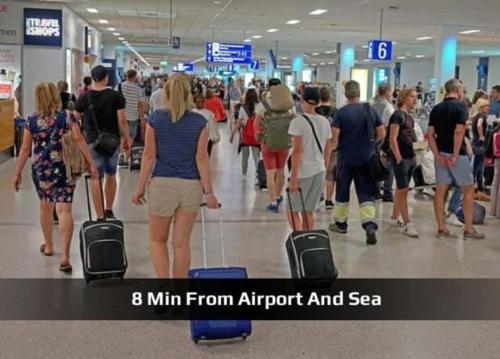 a group of people walking through an airport with luggage at 4 Seasons Island Suites Athens Airport in Markopoulo