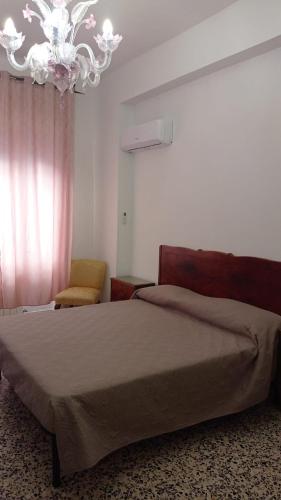 a bedroom with a bed and a chandelier at MARI Home in Cosenza