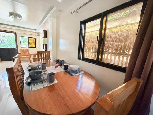 a wooden table in a room with chairs and windows at Medecielo Villa in San Fernando