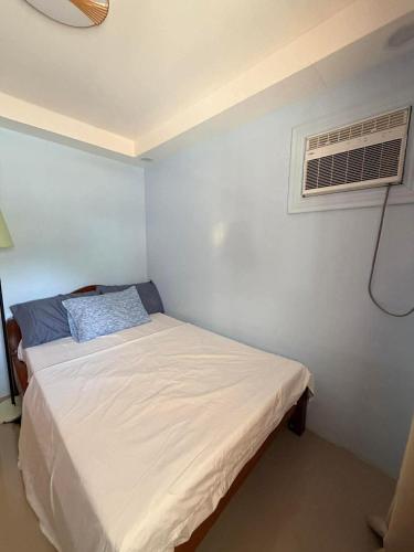 a small bedroom with a bed and an air conditioner at Medecielo Villa in San Fernando