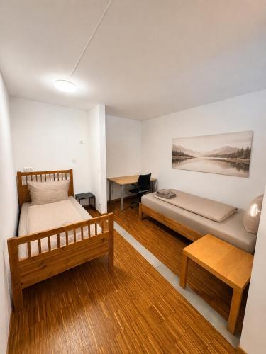 a bedroom with two beds and a desk in it at "Ferienhaus Wonderland in Coburg" - mit Terasse und Parking in Coburg
