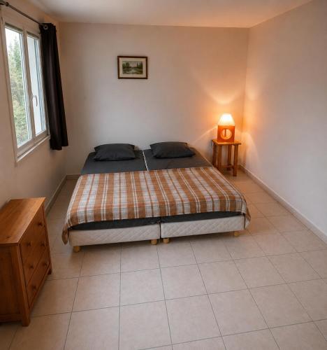 a bedroom with a bed and a table with a lamp at Alizés in Saint-Denis-dʼOléron