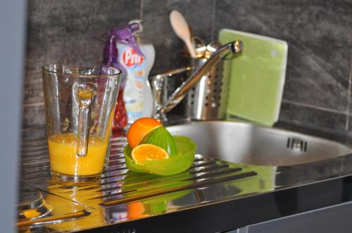 un bicchiere di succo d'arancia su uno stendino accanto a un lavandino di Hostel Villa Domus a Capodistria
