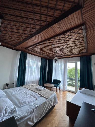 a bedroom with a large bed and a large window at Villa Enhalon in Struga