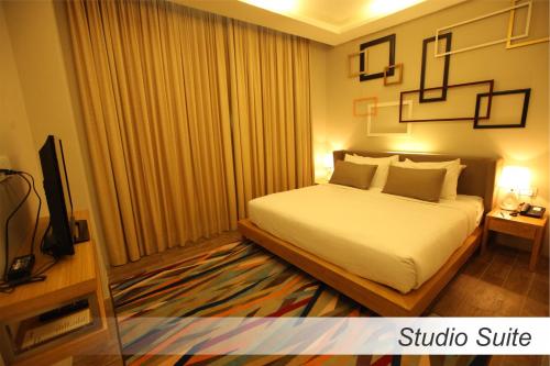 a hotel room with a bed and a television at Casuarina@Meru in Ipoh