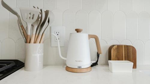 a kitchen counter with a coffee maker and utensils at Villa Verde - Boca Pool & Beach Walk in Boca Raton