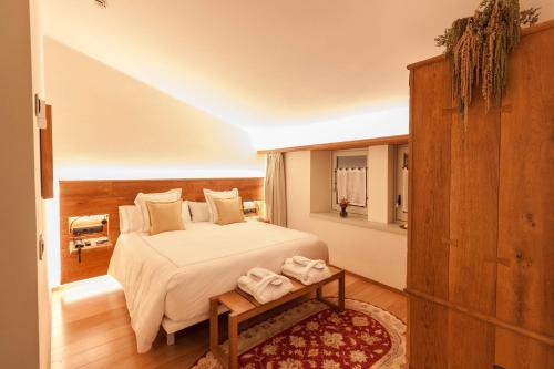 a bedroom with a bed and a table with towels at Hotel Finca Llongarriu - Only Adults in Vall de Bianya