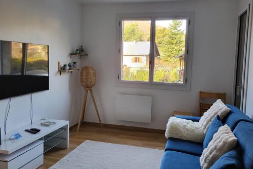 a living room with a blue couch and a tv at Charming apartment overlooking the valley in Briançon