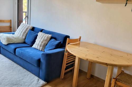 a blue couch and a wooden table in a living room at Charming apartment overlooking the valley in Briançon