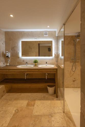 ein Badezimmer mit zwei Waschbecken und einer Dusche in der Unterkunft Le Central Boutique Hôtel in Beaune