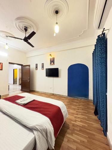 a bedroom with a large bed and a flat screen tv at 3 BHK solana in Jaipur