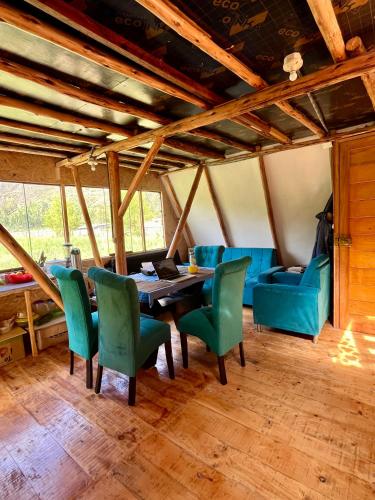 a dining room with a table and green chairs at Awki Wasi - Sacred Valley in Lamay