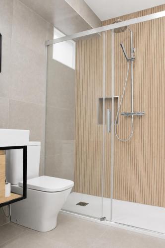 a bathroom with a toilet and a glass shower at Apartamentos Dulce Estrela in Tui
