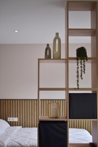a bedroom with a bed and a shelf with a plant at Apartamentos Dulce Estrela in Tui