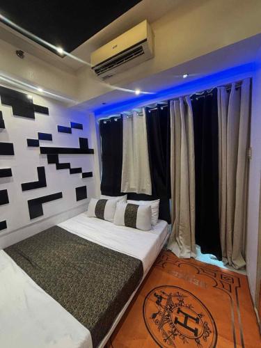 a bedroom with a large bed with blue lights at JJ Staycation Tower 2 in Manila