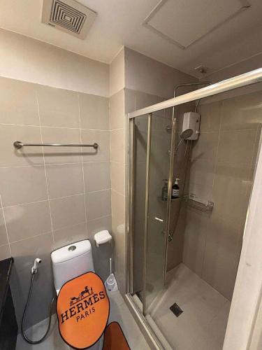 a bathroom with a shower and a toilet with a sign on it at JJ Staycation Tower 2 in Manila