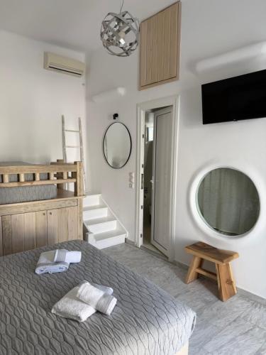 a bedroom with a bed and a flat screen tv at Starlight Luxury Studios in Mikonos