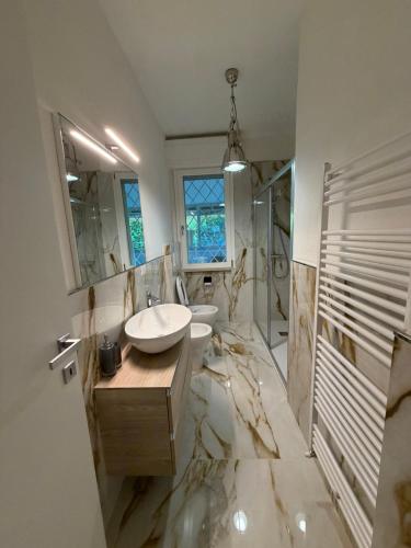 a bathroom with a sink and a mirror at Effealatapartments - L'Oasi del Forte in Forte dei Marmi