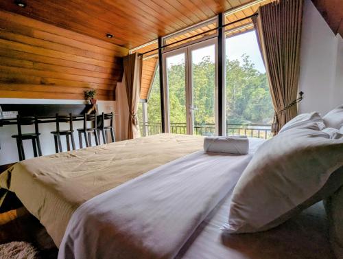 a large bed in a room with a large window at Keshiya Holiday Home in Nuwara Eliya