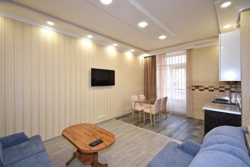 a living room with a blue couch and a table at Рядом с метро in Yerevan