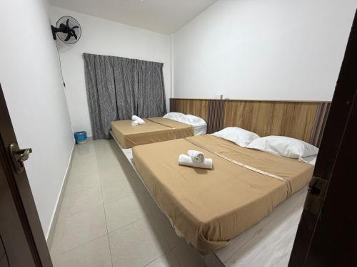 two beds in a hotel room with towels on them at AmaniStay Cameron Highlands in Cameron Highlands