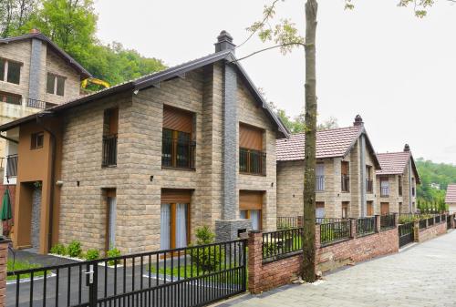 a row of brick houses with a black fence at Sharr Mount in Prizren
