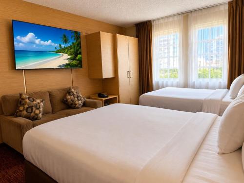 a hotel room with two beds and a flat screen tv at Ocean Beach Club in Fort Lauderdale
