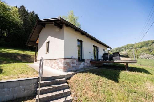 ein kleines weißes Haus mit Veranda und Treppe in der Unterkunft WaldLoft - Südsteiermark in Heimschuh