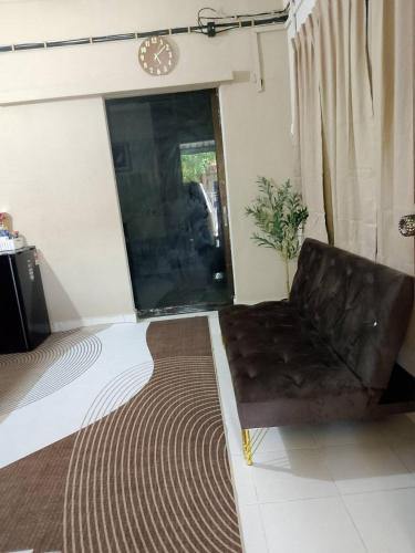 a living room with a leather chair and a rug at Tipika Room Pasir Pekan in Tumpat