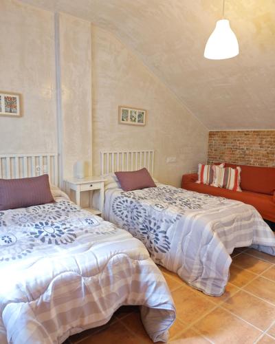a bedroom with two beds and a couch at Entre Vistas in Zahara de la Sierra