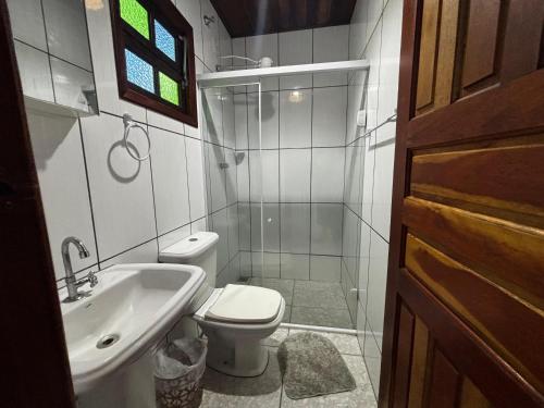 a small bathroom with a toilet and a sink at Pousada Figueira in Trindade