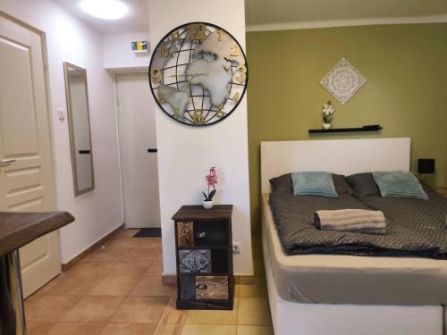 a bedroom with a bed and a mirror on the wall at Erkel apartman in Harkány