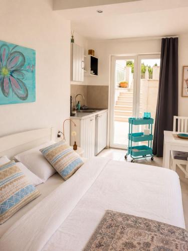 a bedroom with a large white bed and a kitchen at Gradolina Apartment in Pula