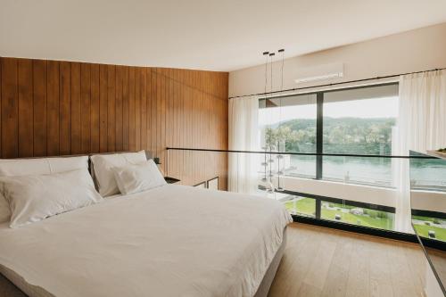 a bedroom with a large bed and a large window at Espadrina Wellness & Spa in Ljubovija