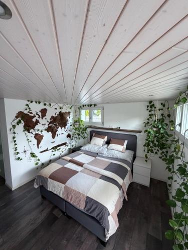 a bedroom with a large bed and plants at Modern apartment with garden in Lostorf