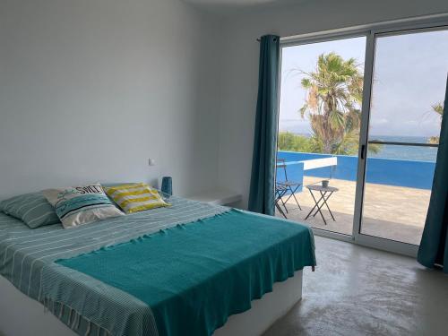 a bedroom with a bed and a view of the ocean at Cap-Azul in Porto Novo